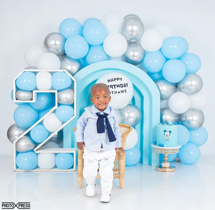 2nd birthday photoshoot, blue and silver balloon arch with a toy car