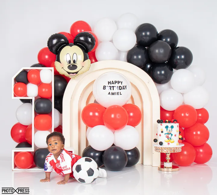 First birthday cake smash photoshoot, football and Mickey Mouse themed balloon arch