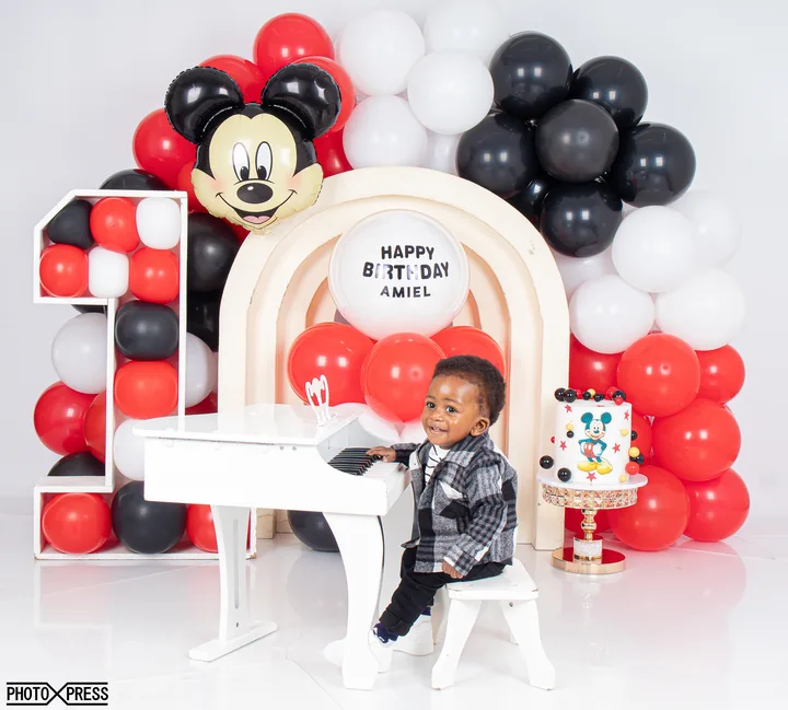 First birthday cake smash photoshoot at a toy piano, football and Mickey Mouse theme